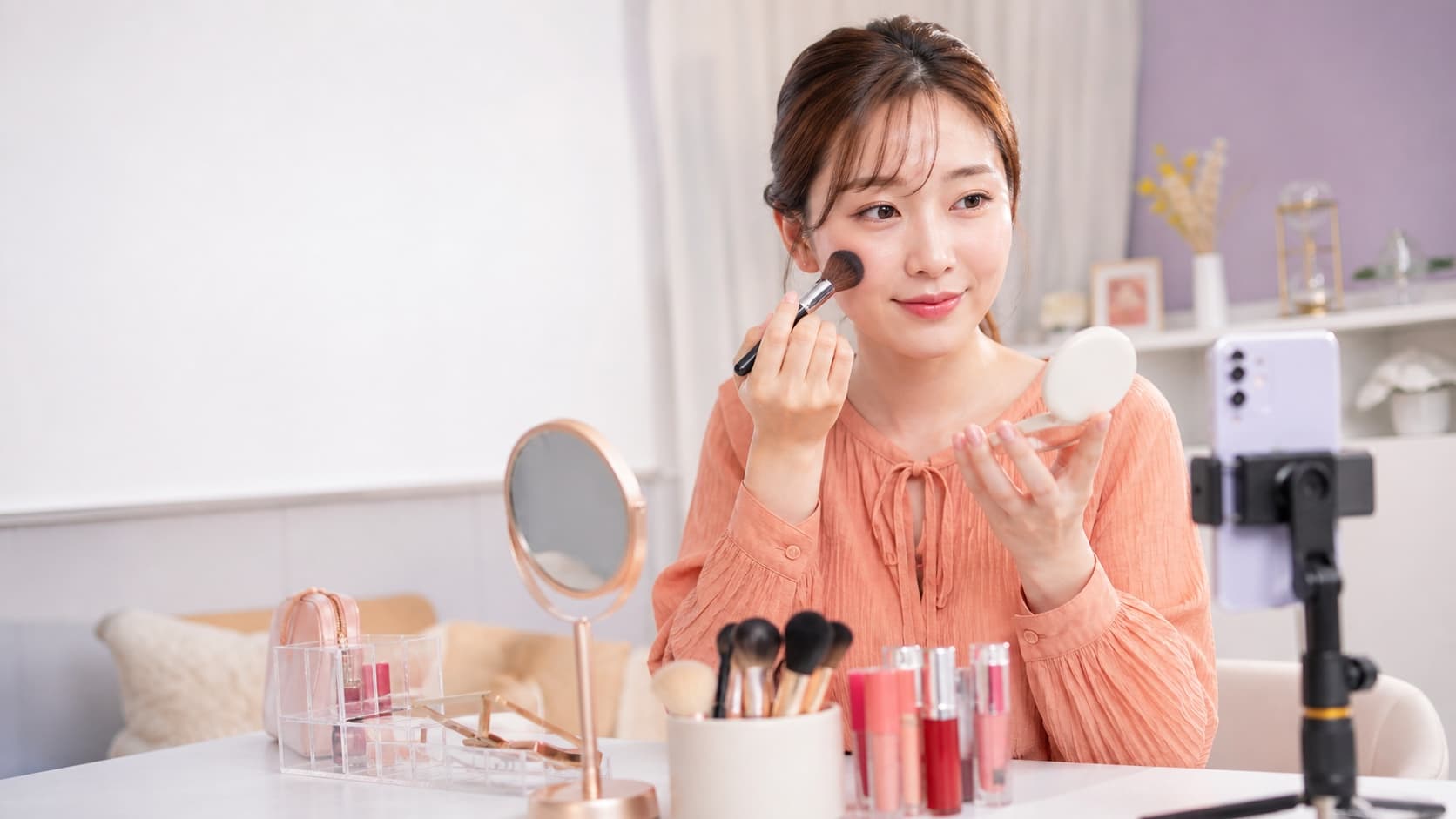 配信ライトとスマホ画面でチークの見え方を確認する女性